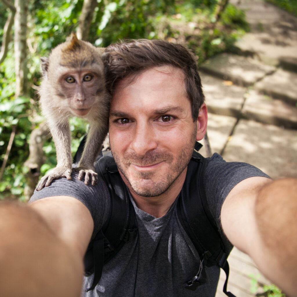 Travel magazine editor Michael Bonocore takes a selfie with a Rhesus macaque monkey